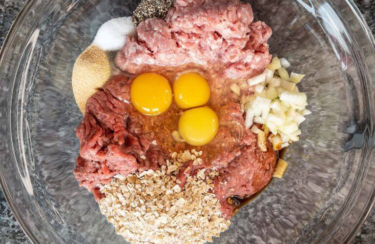 ingredients for classic beef burger recipe in clear glass bowl