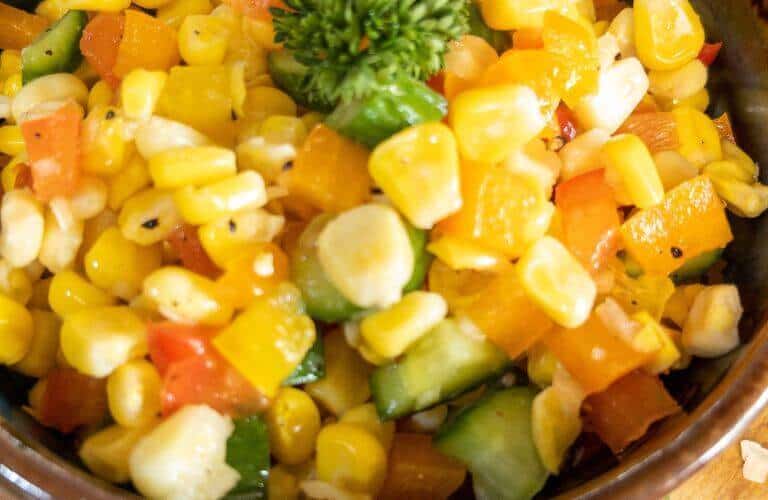 close up of corn salad in a brown bowl