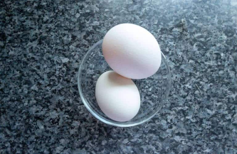 eggs in clear bowl on dark counter
