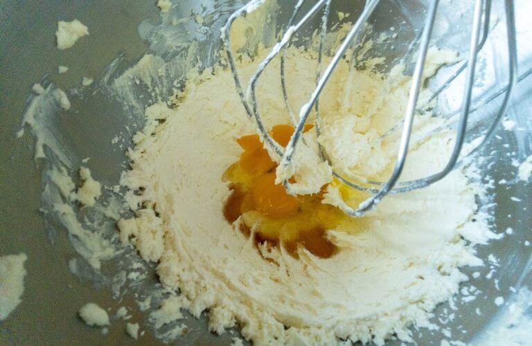 KitchenAid beater with margarine, sugar, eggs and vanilla in metal bowl for rhubarb cupcake treats