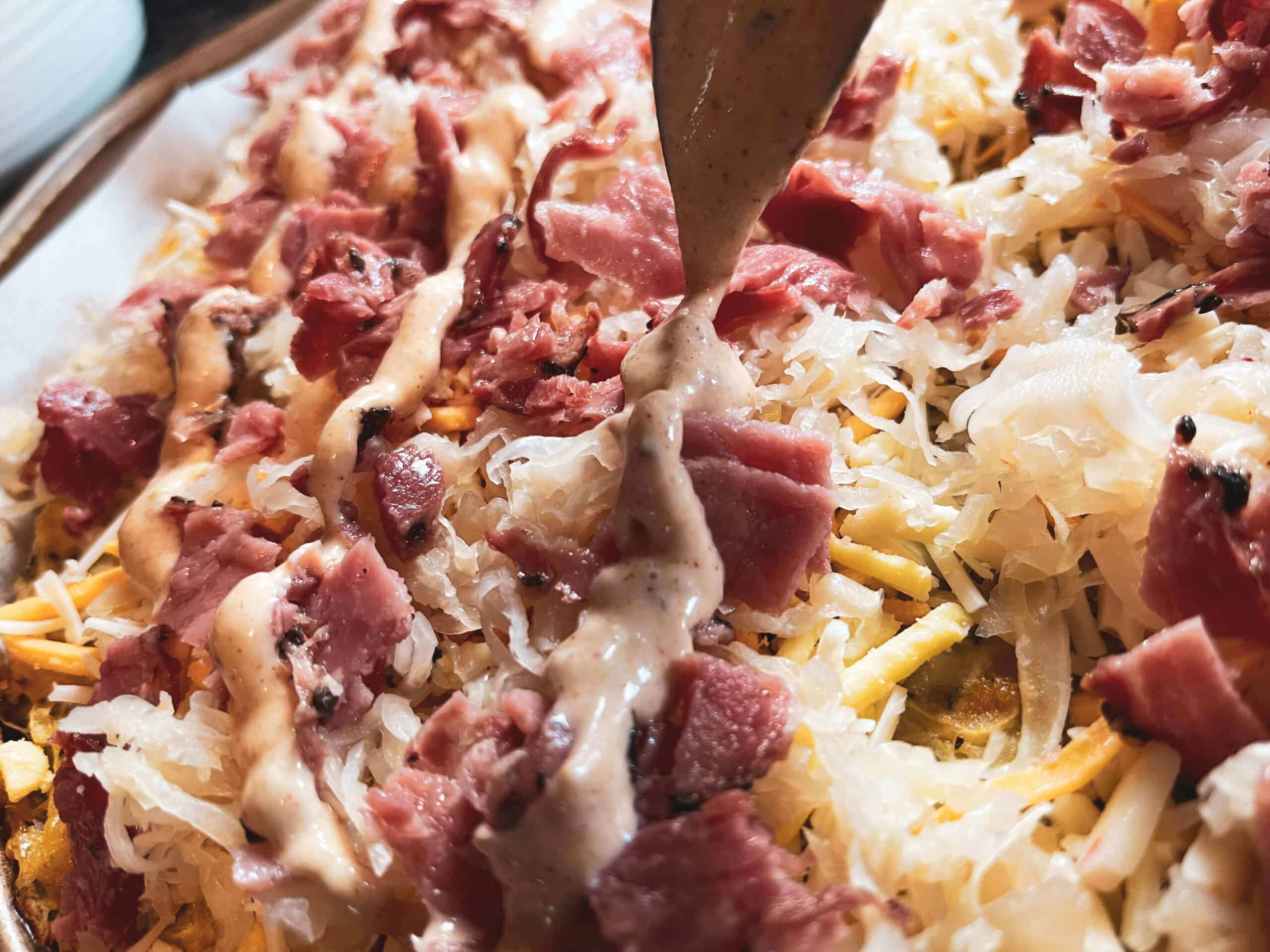 dressing drizzled over a gluten-free Reuben pizza