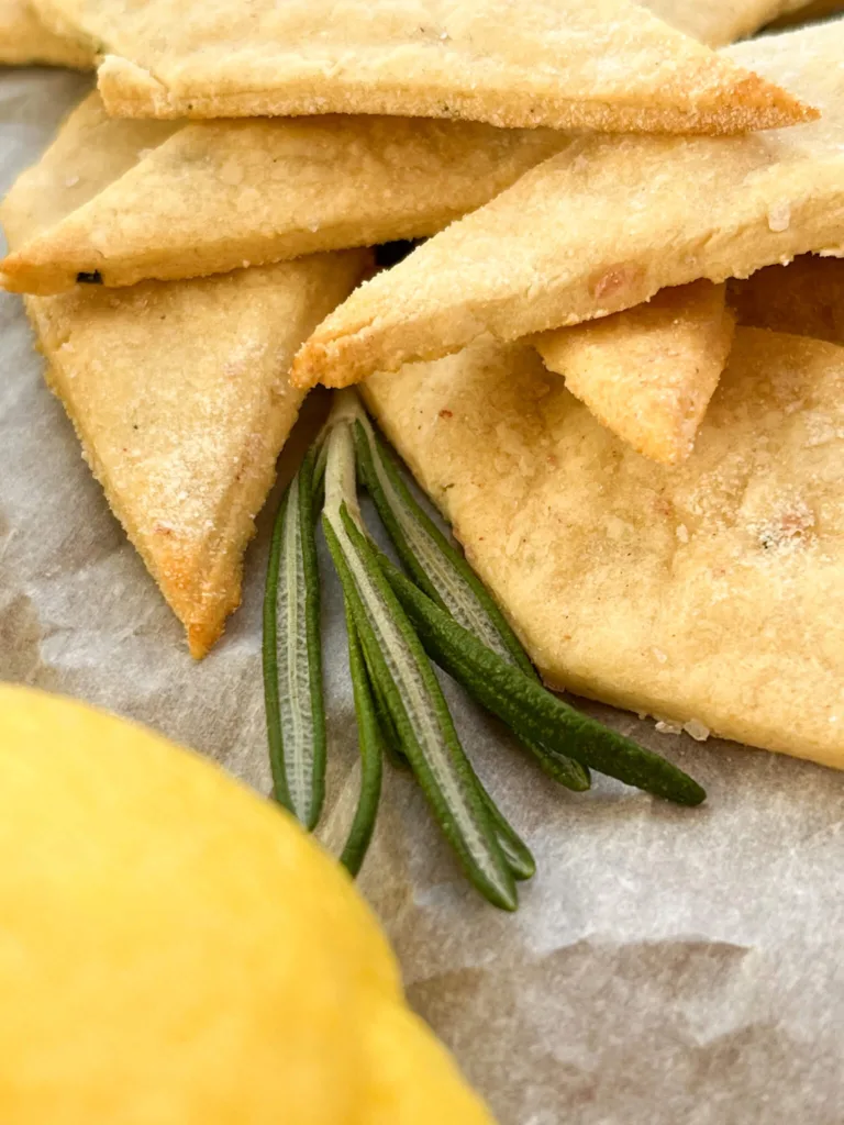 gluten-free-lemon-rosemary-sourdough-discard-crackers on a piece of parchment paper
