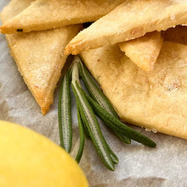 gluten-free-lemon-rosemary-sourdough-discard-crackers on a piece of parchment paper