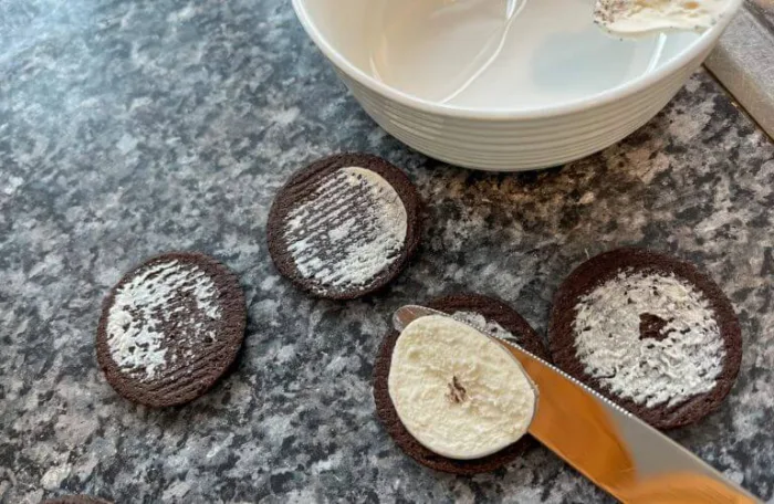 A gluten-free oreo cookie center being removed for the no-bake Oreo cheesecake crust recipe, showcasing the perfect blend of textures