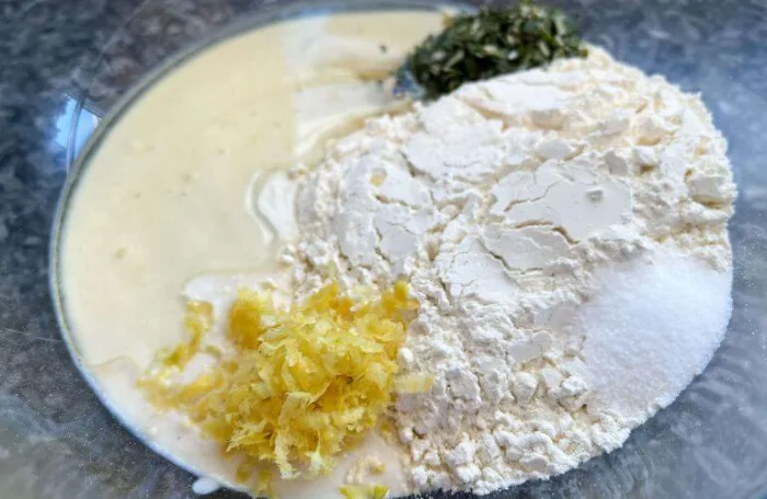 Ingredients for gluten-free lemon rosemary sourdough discard crackers in a glass mixing bowl