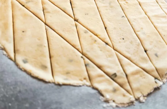 a close up of the gluten-free lemon rosemary sourdough discard cracker dough diamond pattern