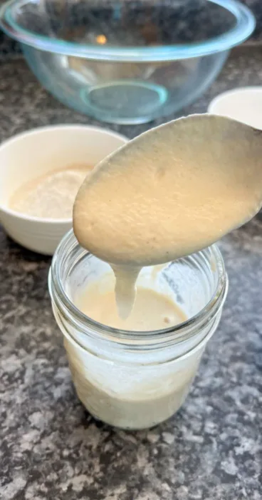 Sourdough starter jar with spoon for making gluten-free pancakes
