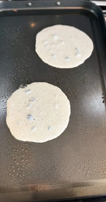 gluten-free sourdough discard pancakes on the grill, kissed with lemon and studded with blueberries!