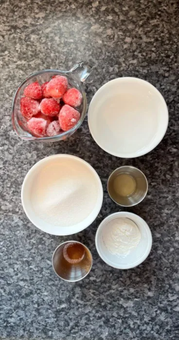 Ingredients for gluten-free strawberry sauce arranged on a kitchen counter.