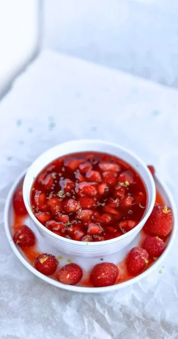 A bowl with a generous serving of homemade strawberry sauce, topped with lemon zest creating a tempting breakfast treat.