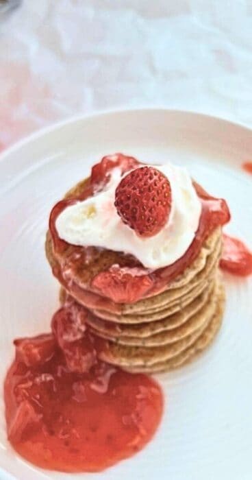 Adding fresh strawberries to gluten-free sourdough discard pancakes for a burst of flavor