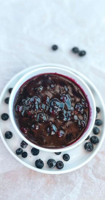 White glass dish showcasing vibrant blueberry topping, an easy recipe for those avoiding gluten and dairy.