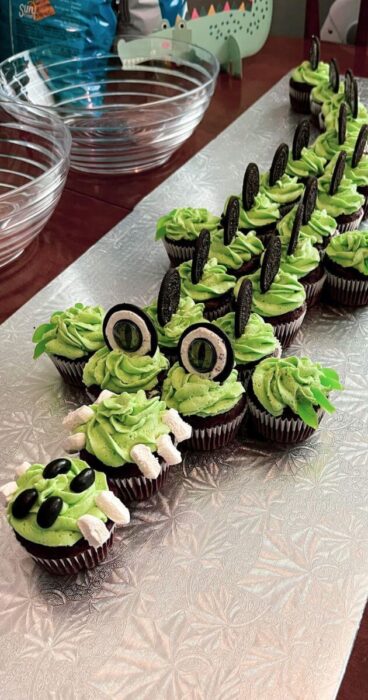 An adorable dessert resembling an alligator, crafted from intricately arranged cupcakes.