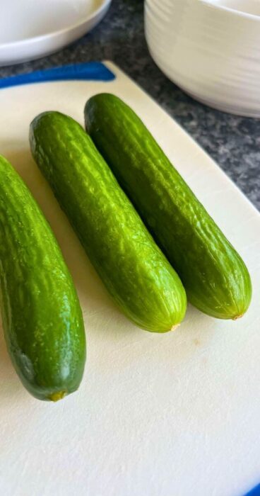 Mini cucumbers for a salad featuring smashed pieces accented by aromatic dill, ideal for gluten-free diets.