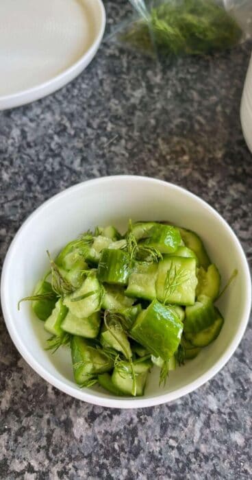 Sliced cucumbers smashed and combined with vibrant green dill for a refreshing gluten-free dish.