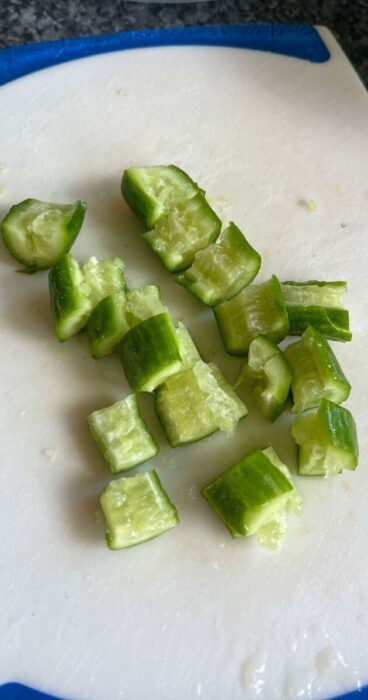 Close-up of smashed cucumbers on a cutting board for a gluten-free smashed cucumber salad