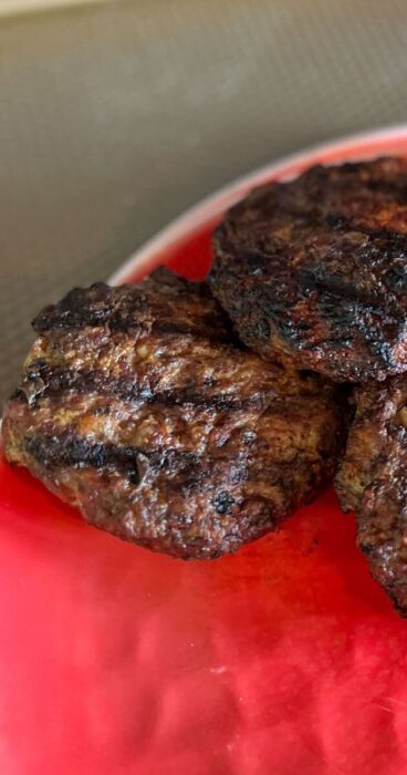 Gluten-free beef bacon burger with bacon infused into the patty, served on a plate with no bun.