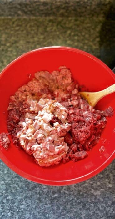 Close-up of ground grass-fed beef, ground pork, and chopped bacon in a bowl for a gluten-free beef bacon burger