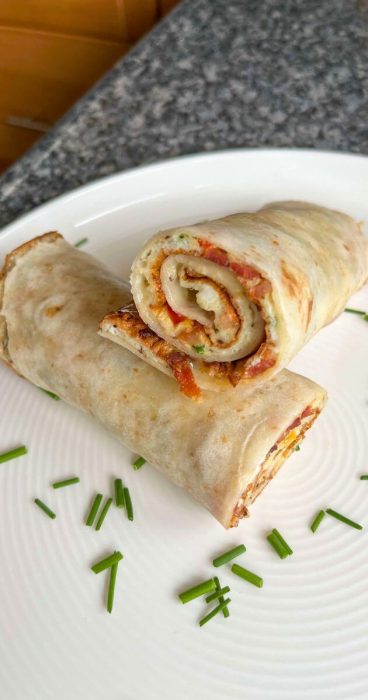 Egg omelet breakfast wrap in a gluten-free tortilla, perfect for a quick and healthy meal.