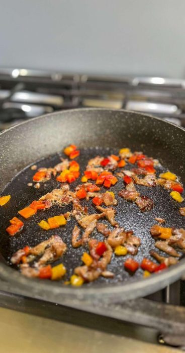 savory bacon and peppers in a skillet for a gluten-free breakfast wrap